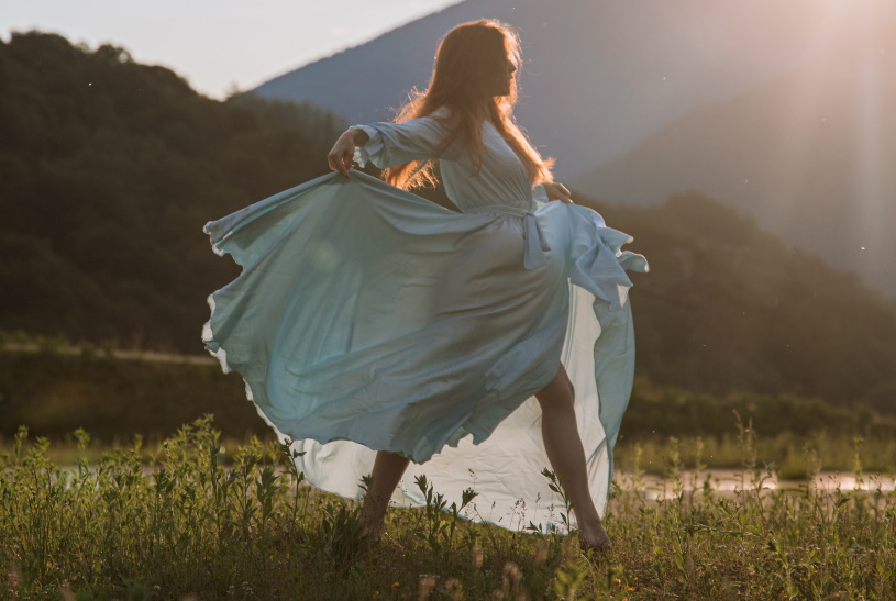 Frau im Kleid auf einer Blumenwiese