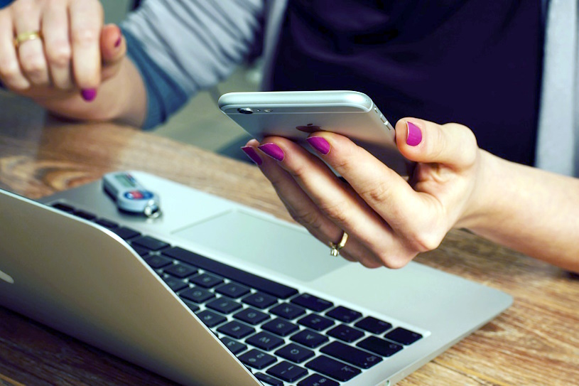 Frau mit Smartphone und Laptop