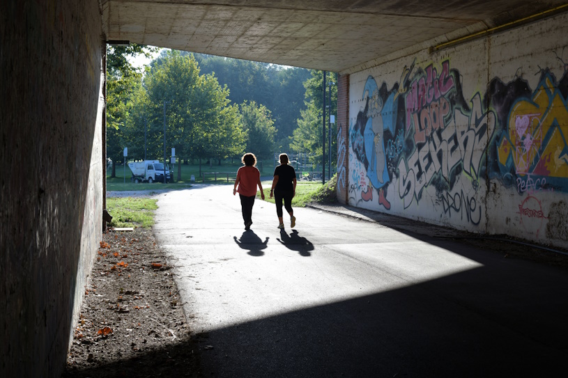 Zwei Frauen gehen unter einer Brücke spazieren Zwei Frauen gehen unter einer Brücke spazieren